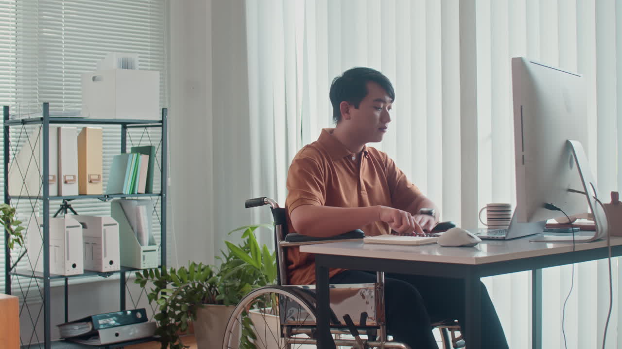 Developer in Wheelchair Programming Code on Computer