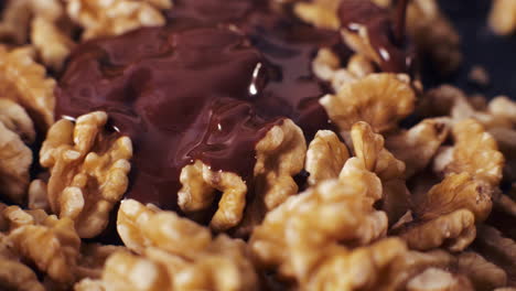 melted chocolate pouring over walnuts
