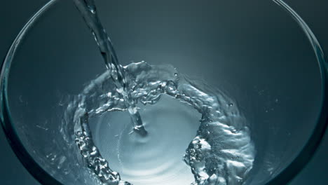 filtered aqua jet filling glass closeup. clear water flowing inside vessel