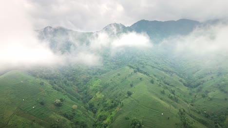 Drone-flying-through-clouds-revealing-gorgeous-mountain-range-in-Central-Sumbawa-island,-Indonesia