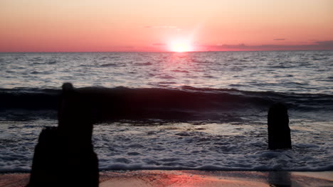 imágenes en cámara lenta de las olas del atardecer sobre rocas dentadas en la costa de jersey