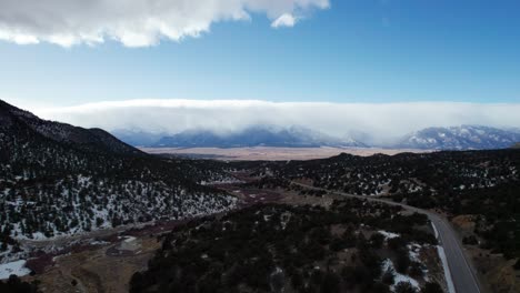 Rising-drone-aerial-view-of-a-remote-highway-in-the-rocky-mountains