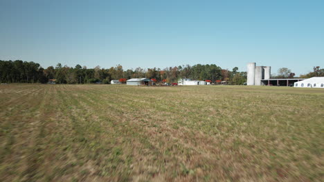 low angle aerial flying over agricultural field on farm