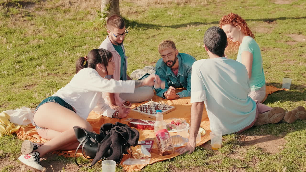 Friends Enjoying a Picnic and Chess in the Park