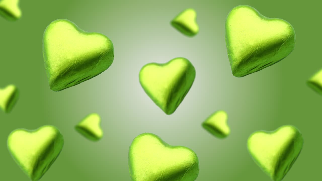 Flying A heart shape wrapped chocolate candy flying and wiggle of different diameters on a trending turquois gradient background. High quality 4k UHD footage
