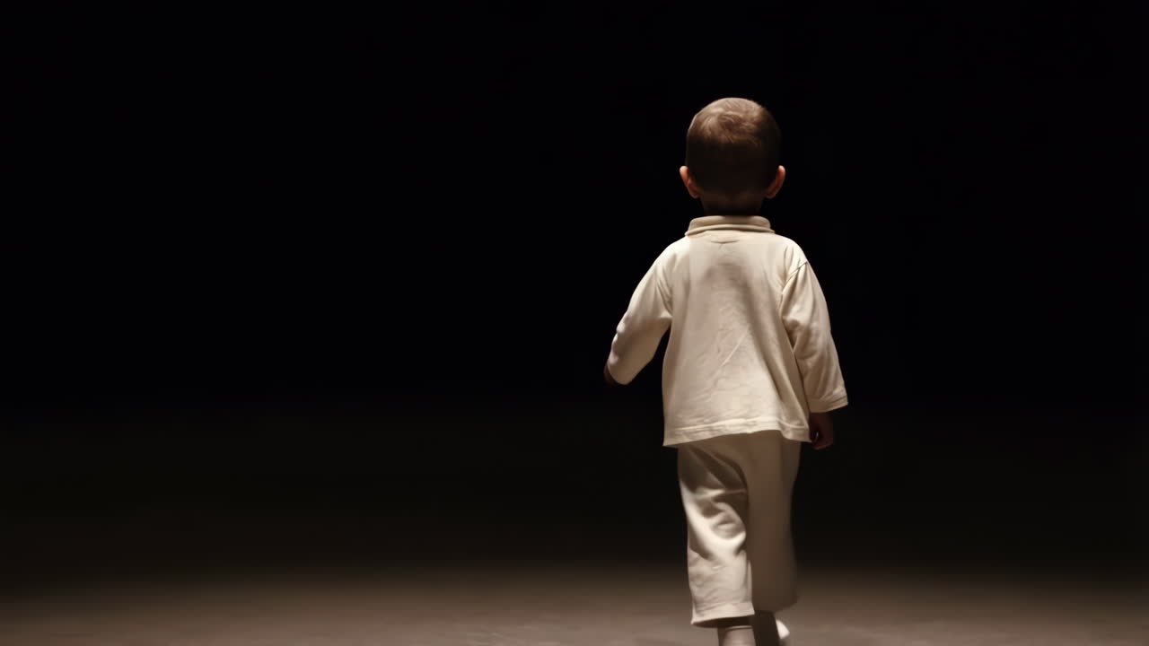 A young child walks into a dark, unknown space