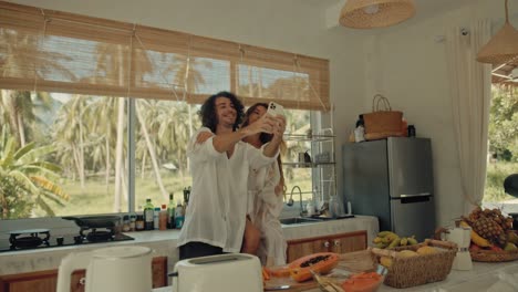 couple taking a selfie in a tropical kitchen