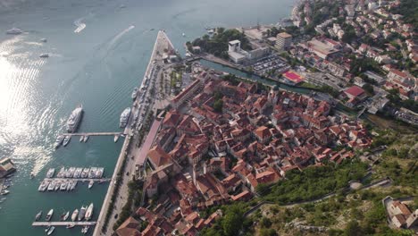 kotor montenegro: coastal aerial tilt-up reveal showcasing old town and mountains