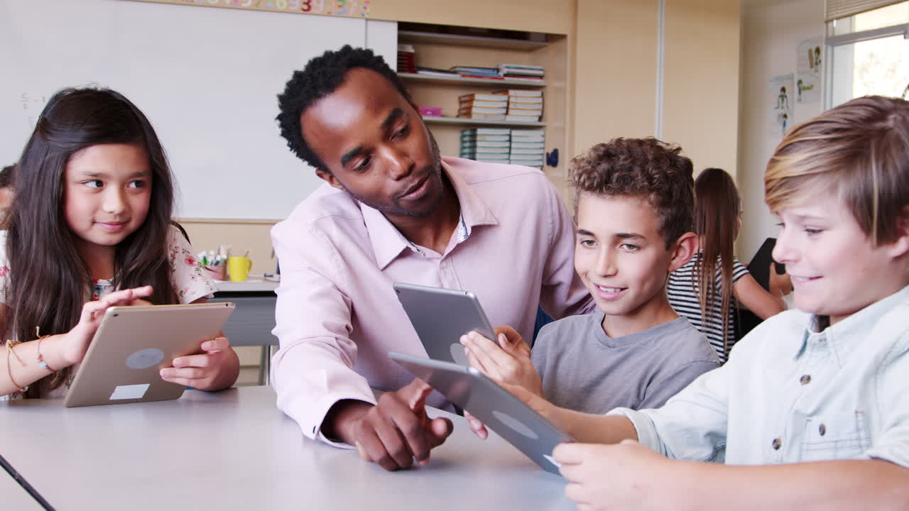 maestro entre los niños con tabletas en la clase de escuela primaria