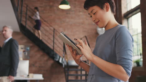 stylish asian business woman using digital tablet in boardroom