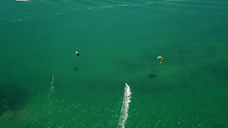 Drohnenaufnahme-Von-Oben-Nach-Unten-In-Großer-Höhe-Von-Kitesurfern-Im-Türkisfarbenen-Atlantik