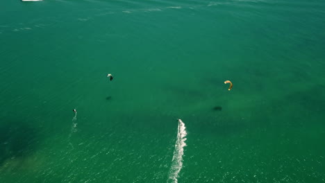 high altitude top down drone shot of kite surfers in turquise atlantic ocean