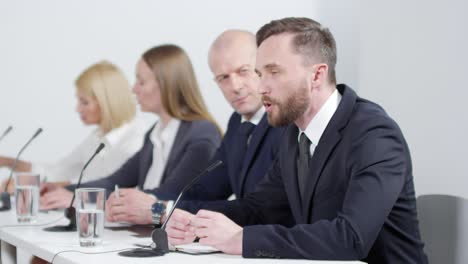 man speaking into microphone during corporate press conference