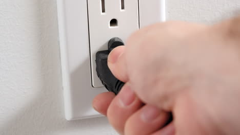 unplugging an extension cord or appliance power cord from the wall outlet