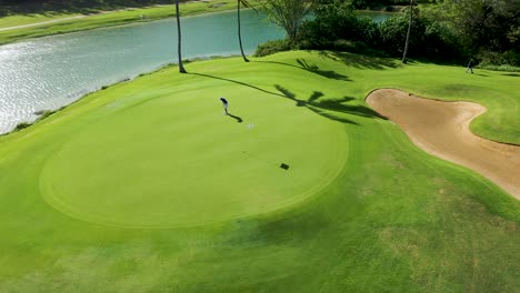 Golfer-Auf-Dem-Putting-Green-Verfehlt-Den-Schlag-Aerial-Schuss-4k