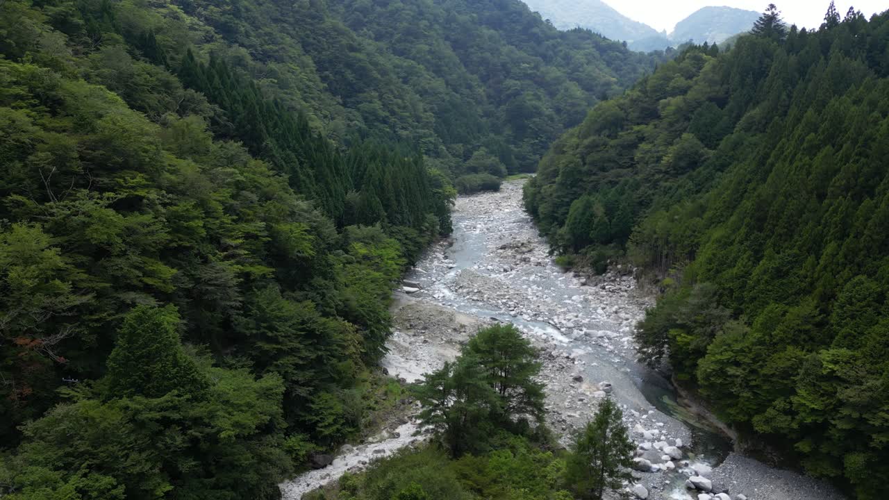 Beautiful drone flying upwards over Yushin valley riverbed