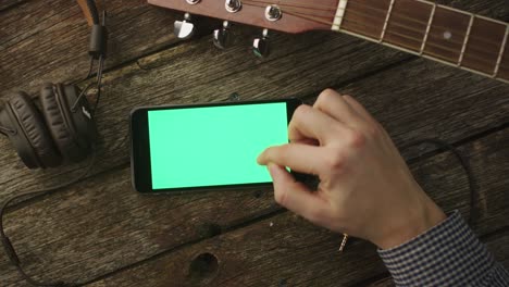 músico usando el teléfono en modo paisaje en casa. vista superior. estilo de vida causal
