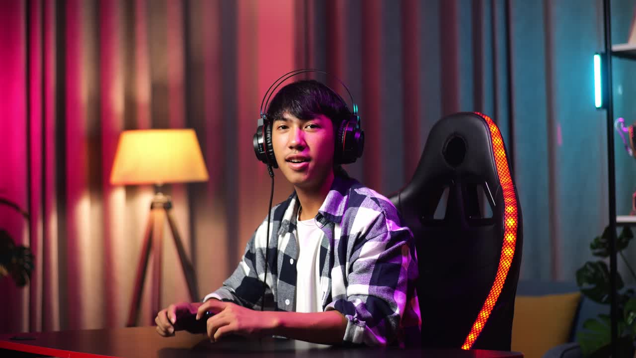 Asian Teen Boy Gamer Smiling To Camera With Crossed Arms While Playing Video Game On Smartphone