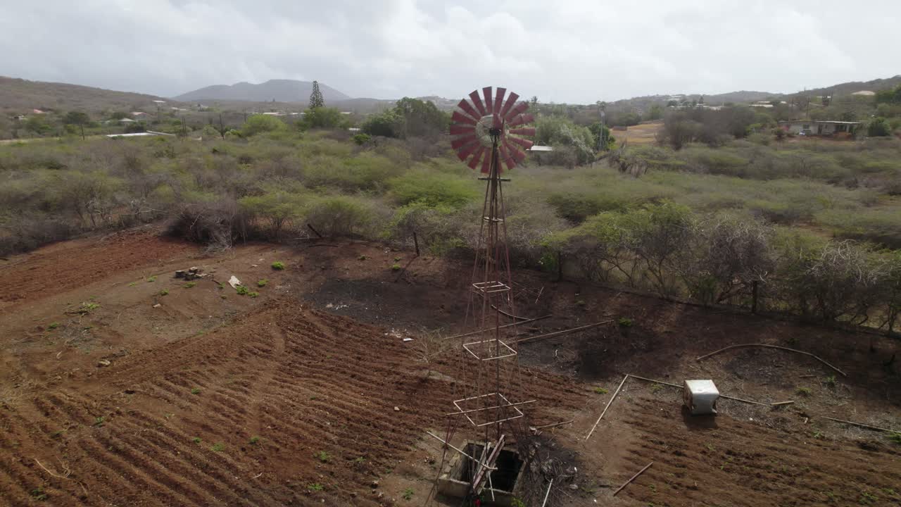 la bomba de agua del molino de viento en una granja desierta debido al calentamiento global - toma aérea de drones