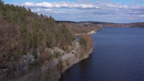 car driving beside a lake in sweden, outside gothenburg, sweden