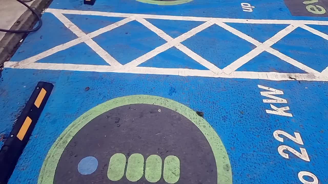 Electric vehicle power charging station installation asphalt marking signs on the ground