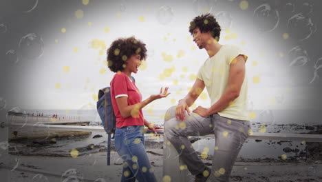 young couple talking by seaside with yellow bubbles animation overlay