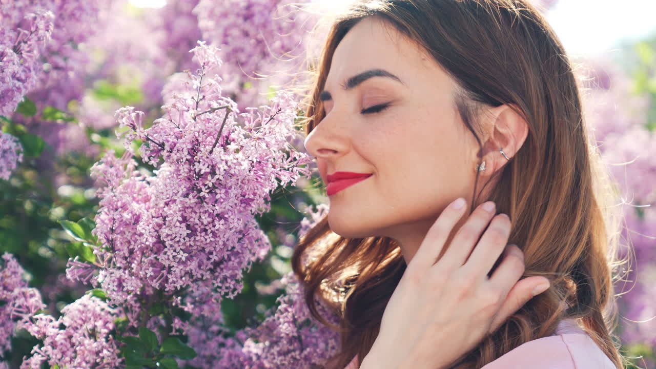 Donna che si gode i fiori di lillà primaverili