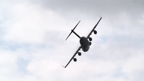 low angle tracking shot of a c-17 airlifter in a steep left turn