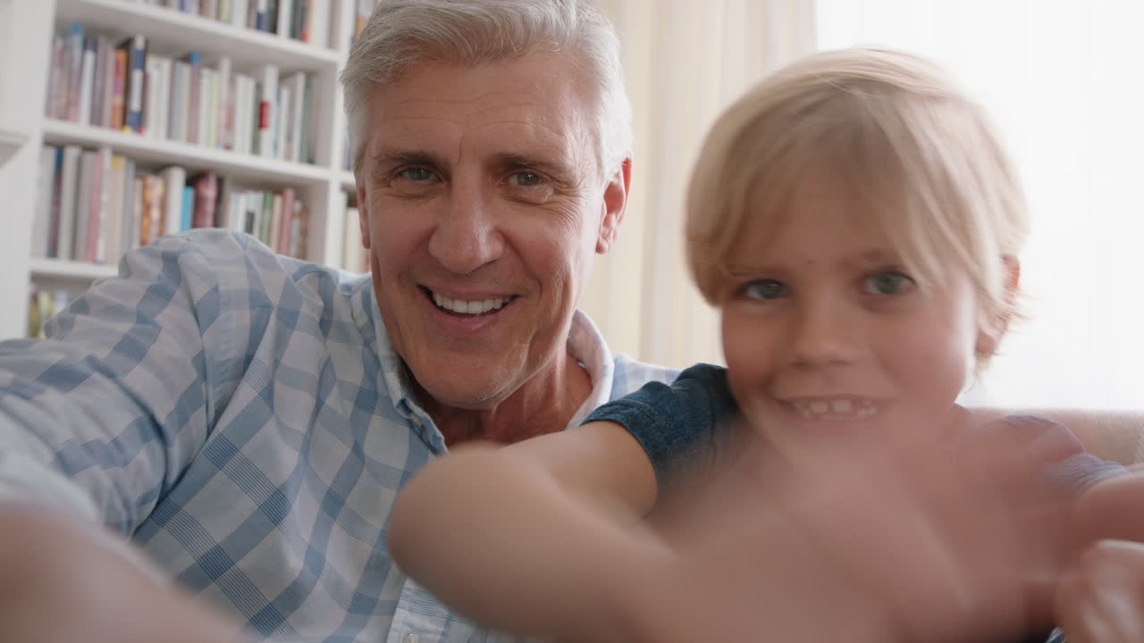 grandfather and child having video chat little boy sharing vacation weekend with family grandpa enjoying chatting on mobile technology at home with grandson pov 4k