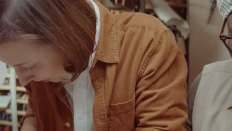 Diverse-Female-Shoemakers-Working-Together-at-Desk-in-Workshop