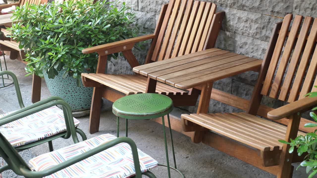 Outdoor Patio Seating Area with Wooden Chairs and Greenery
