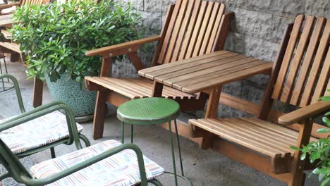 outdoor patio seating area with wooden chairs and greenery