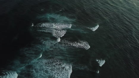 Waves-around-Diamond-Head-on-Oahu,-Hawaii-with-dark-blue-tones