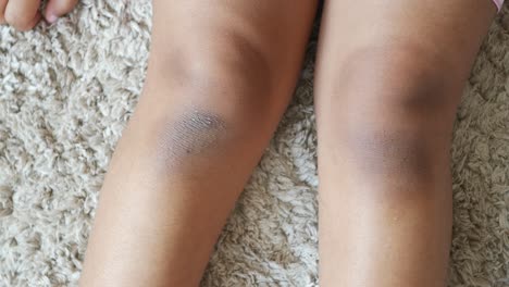 close-up of two brown knees on a carpet