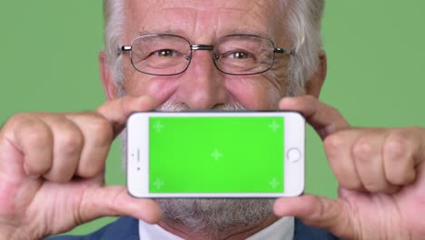 hombre de negocios barbudo y guapo contra un fondo verde.