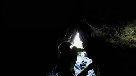 Male-hiker-exploring-a-dark-cave-4k