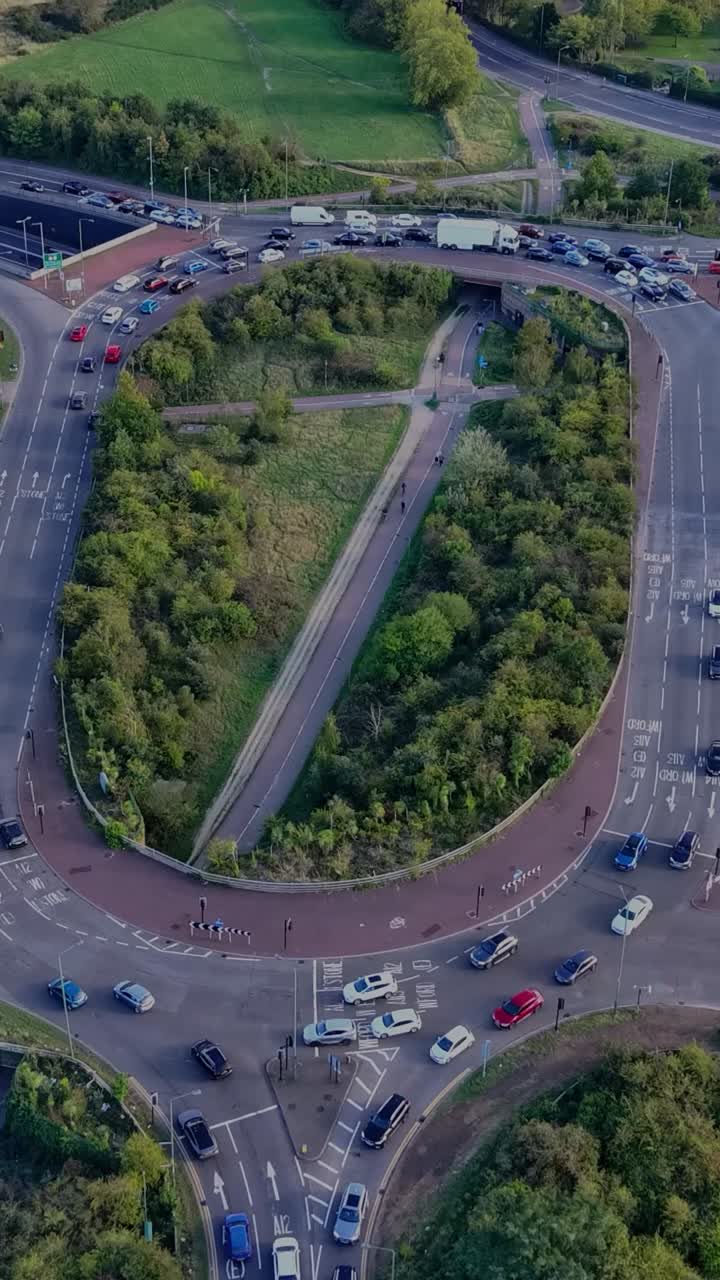 Vertical hyperlapse of the Green Man Roundabout, Leytonstone, London. Drone orbits, creating a clockwise rotating effect as long afternoon shadows, passing clouds, and sunlight play across the scene