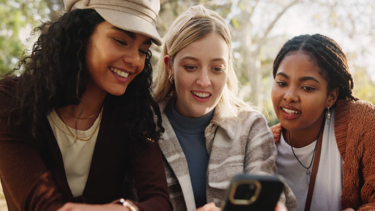 Three female friends looking at a phone