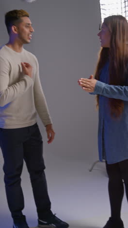 video vertical de actores masculinos y femeninos filmando una escena de película en el estudio en el set de la película filmada en tiempo real