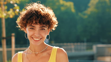 una mujer joven sonriendo en un parque.