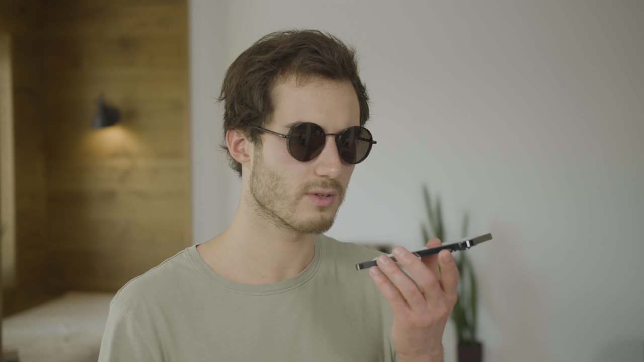 vista en primer plano de un joven ciego hablando por teléfono