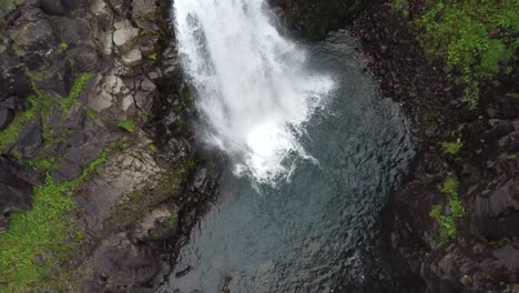 Spectacular-Waterfall-falling-into-river-water-of-mountains-in-Iceland,Europe---Ascending-top-down-view