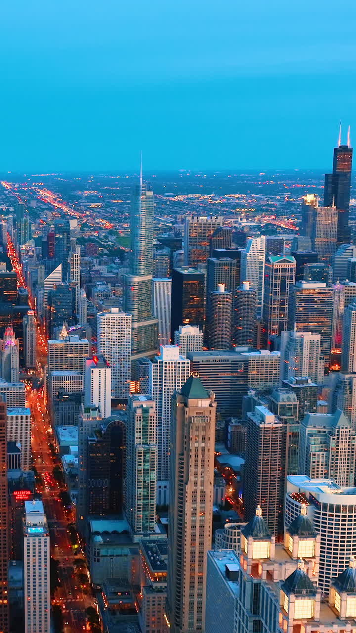 Dusk in Chicago on Michigan Avenue. Aerial view of evening city with street lights. Car traffic. Skyscrapers in the city center