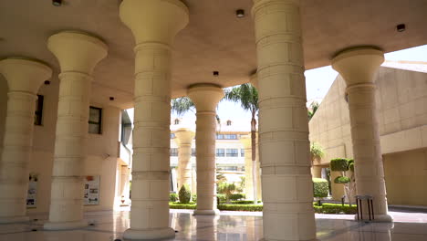 Un-Gran-Edificio-Con-Columnas-Y-Palmeras