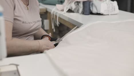 woman cutting fabric in a clothing factory