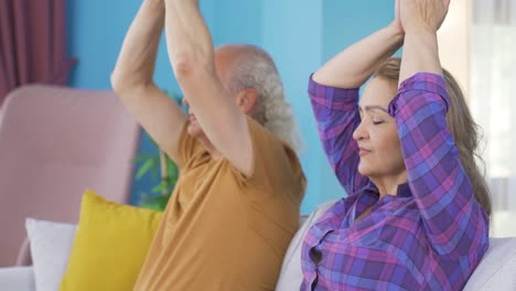 una pareja casada meditando en casa.