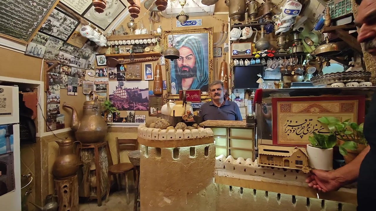 Negoziante mediorientale in piedi in un negozio di antiquariato tradizionale.