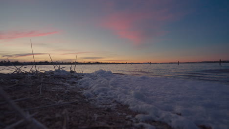 burbujas blancas en la orilla de la laguna rosa durante la puesta de sol en torrevieja en la provincia de alicante, españa