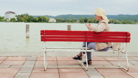 woman on a bench uses phone