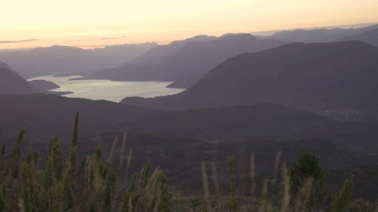 Rack focus from female playing guitar at sunset outdoors to mountains slow motion 60fps